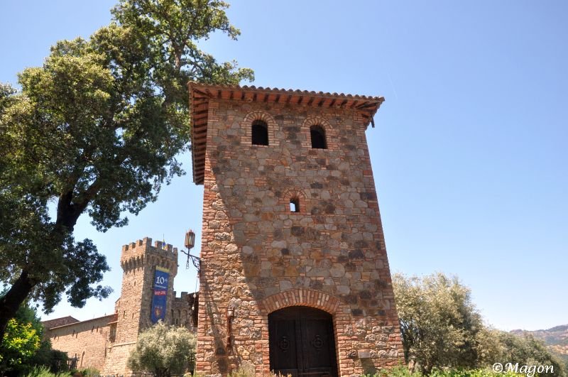 Castello Di Amorosa: каменная башня с арочным входом и узкими окнами